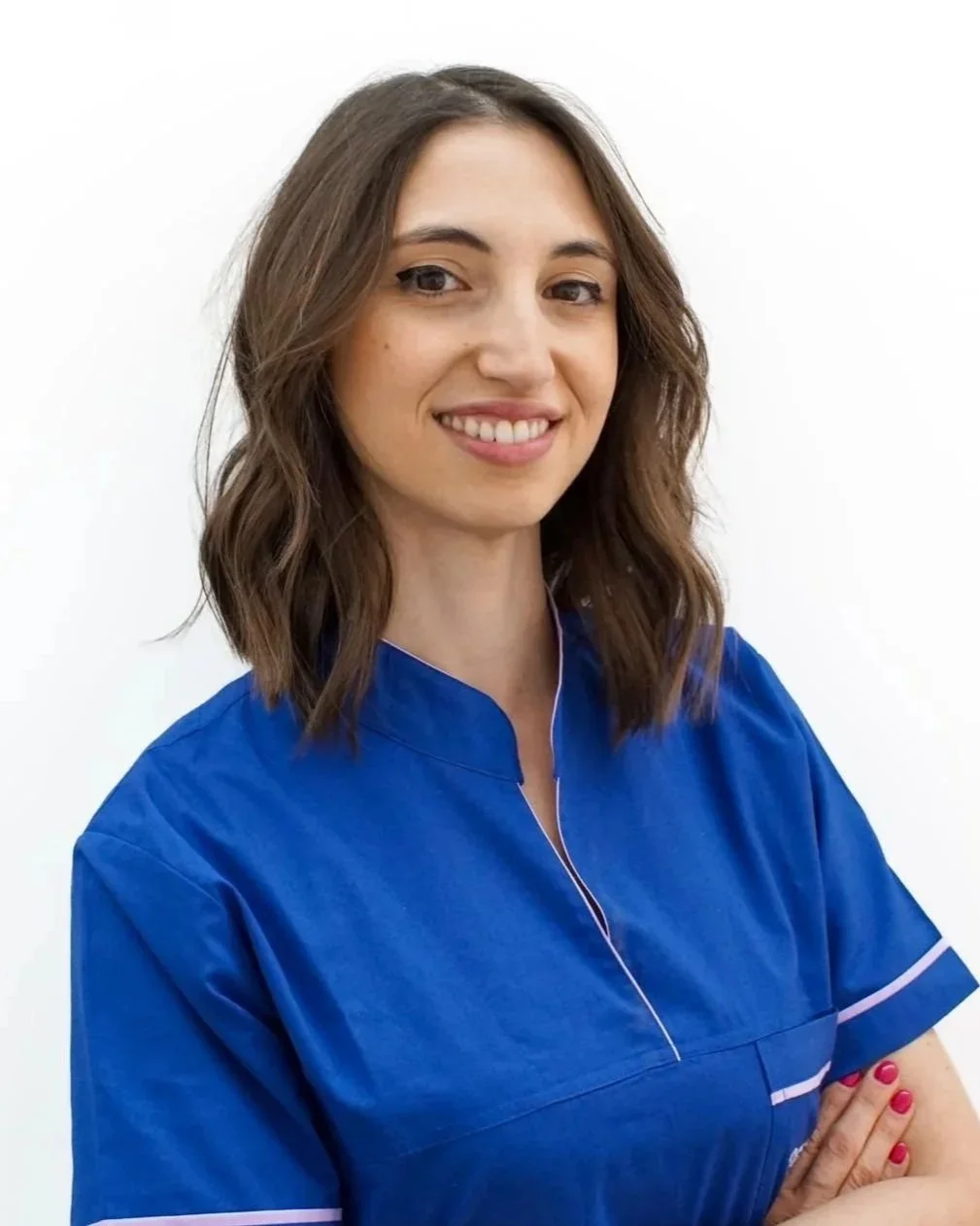 Donna sorridente con capelli ricci e vestita con divisa blu professionale