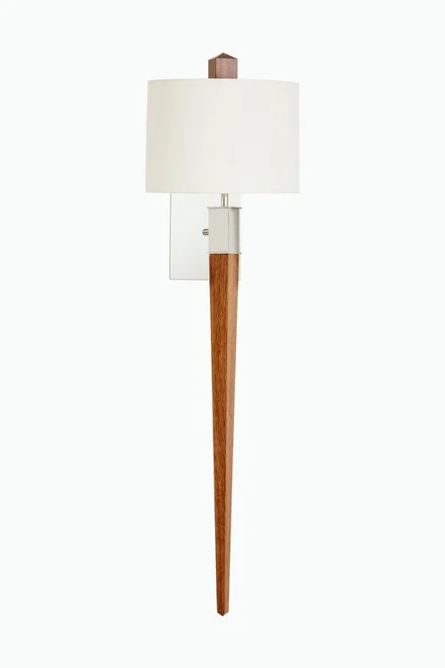 A modern wall-mounted lamp with a white cylindrical shade and wooden arm.