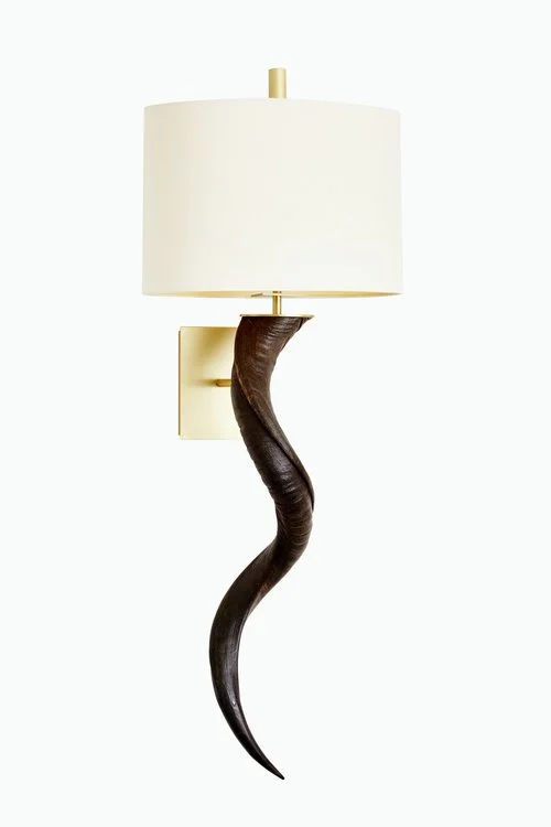 Wall-mounted lamp with a beige fabric shade and a decorative dark curved horn as the arm.