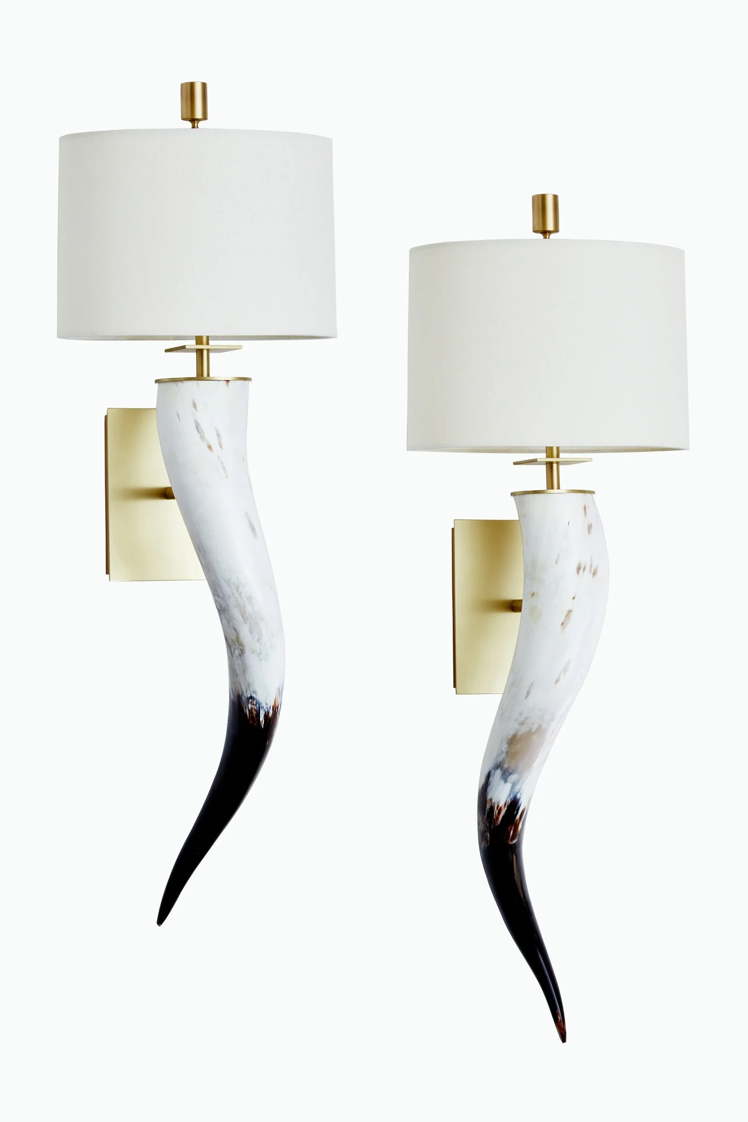 Two wall-mounted lamps with white fabric shades, gold accents, and curved marble bases