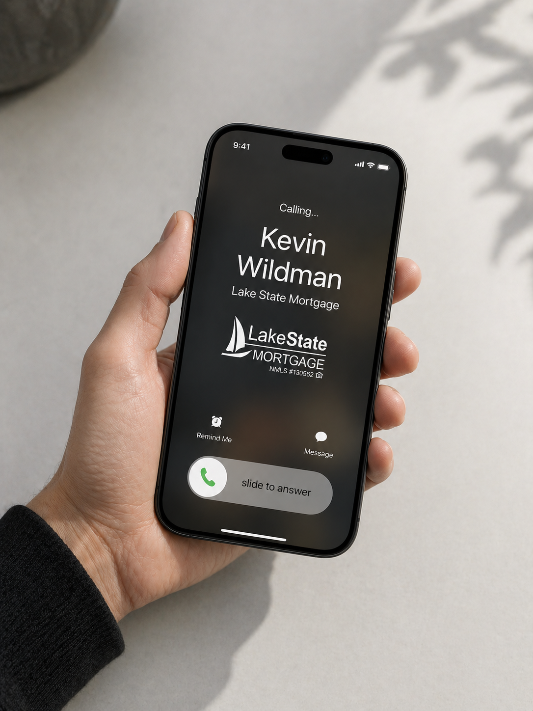 Smartphone displaying an incoming call from Kevin Wildman of Lake State Mortgage, with options to remond me or message.