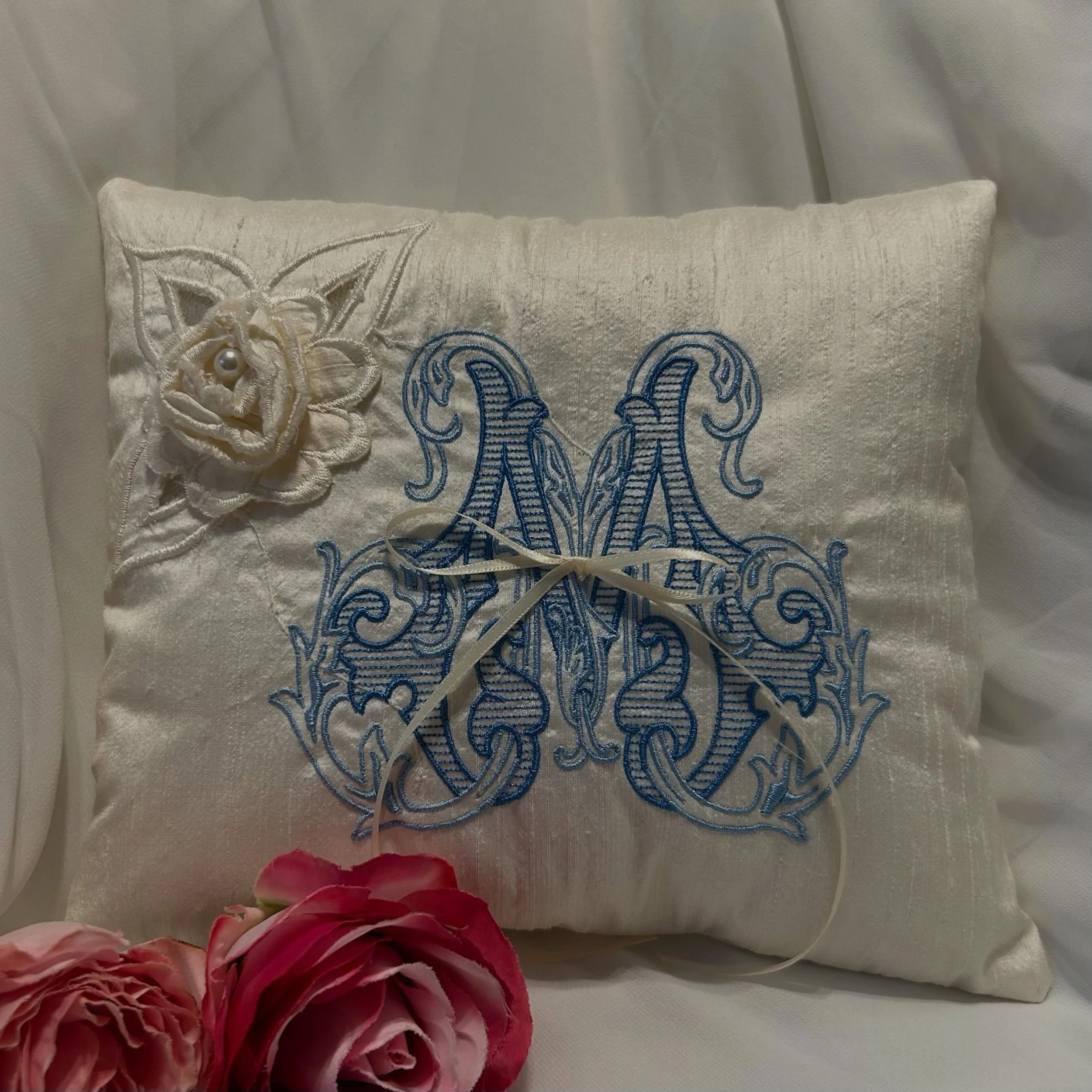 These custom ring pillows were created from our customer&rsquo;s wedding dress with delicate floral details that have pearls in the center. We love turning your ideas into one-of-a-kind heirloom pieces. Every design is unique, just as every love stor
