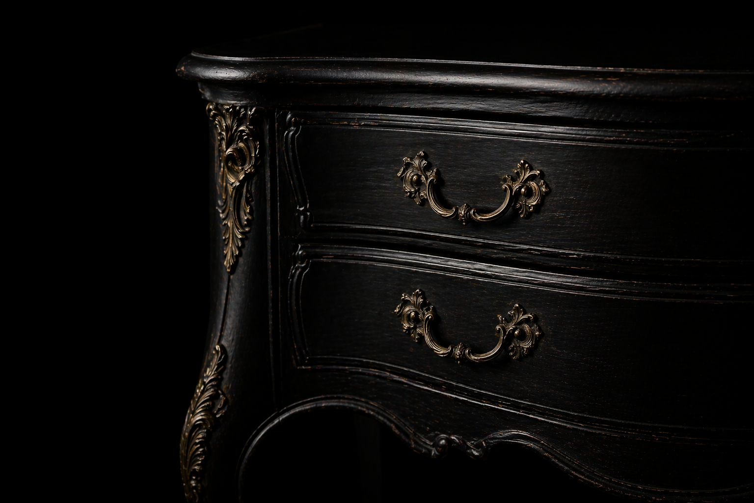 Black antique chest of drawers with carved details and brass hardware.
