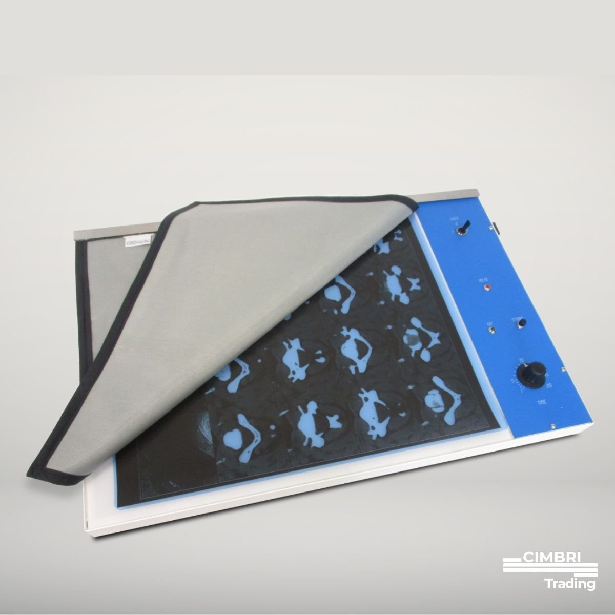 A blue lightbox with a raised cover showing a pattern of blue and black silhouettes of babies or infants, with control knobs and switches on the side, placed on a white surface.