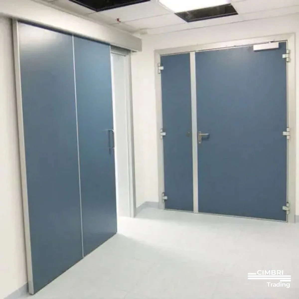 Two blue restroom stalls with closed doors in a public bathroom or similar facility.