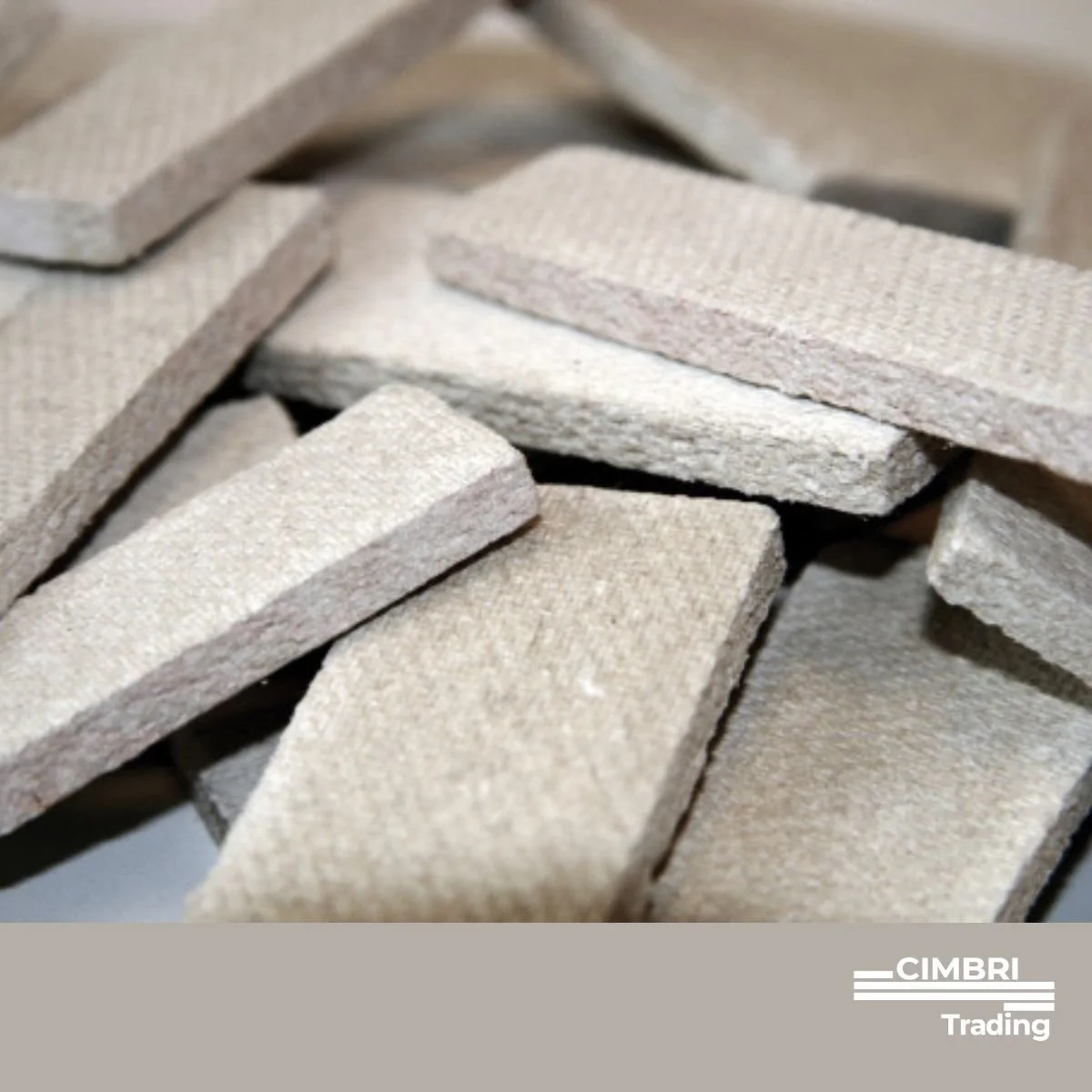 A close-up view of numerous rectangular light gray bricks arranged haphazardly, with the CICMBR Trading logo at the bottom right corner.
