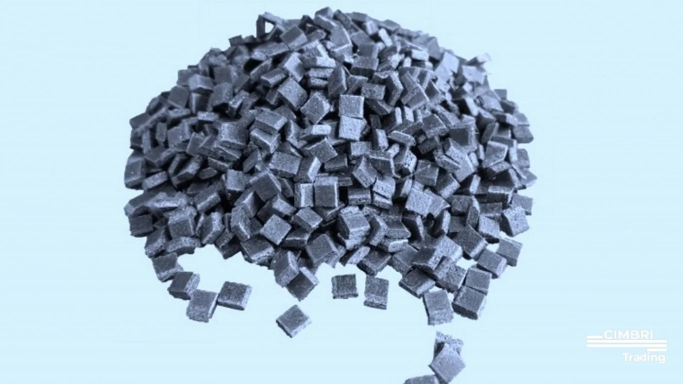A pile of small, dark gray, square charcoal briquettes against a light blue background.