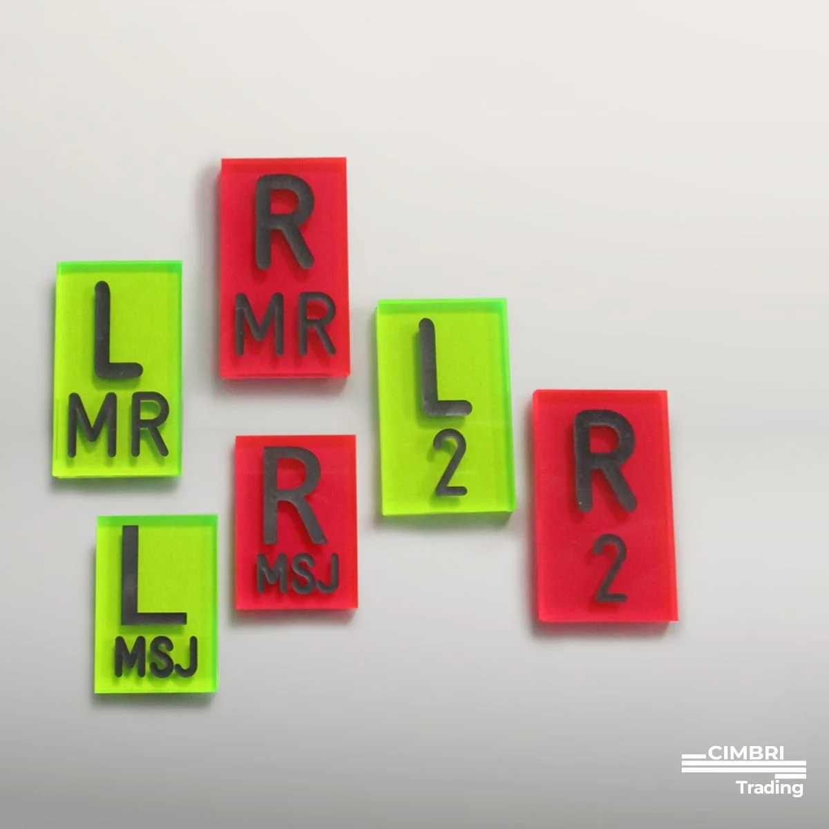 Colorful Scrabble tiles arranged on a white surface, spelling words like 'L', 'MR', 'R', '2', and 'MSJ' with a mix of red and yellow backgrounds.