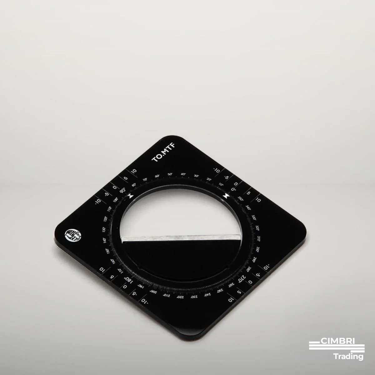 A black circular protractor with degree markings, placed on a white surface, with the logo of CIMBRI Trading in the lower right corner.
