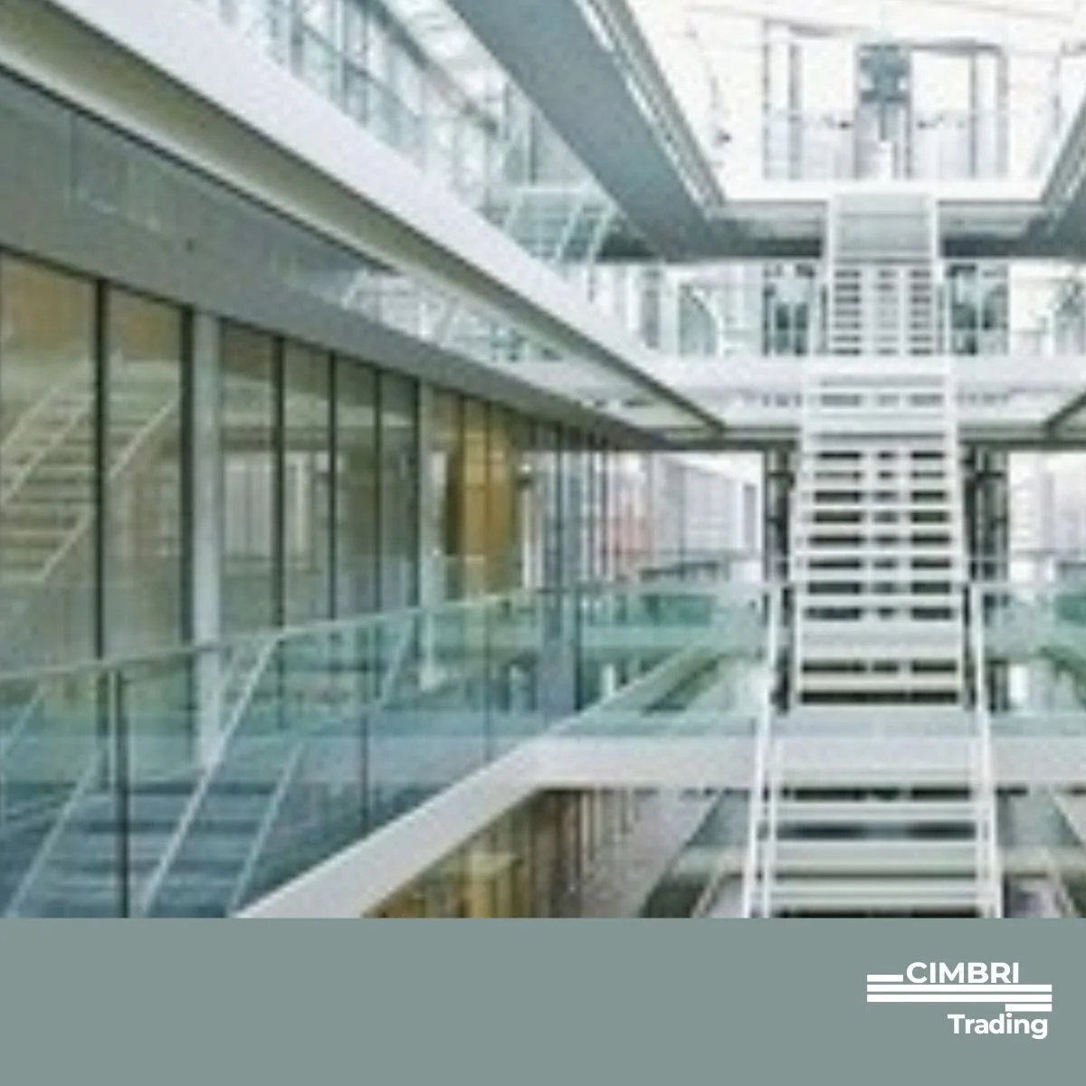Modern office building interior with glass walls, white staircases, and multiple floors visible from the ground level.