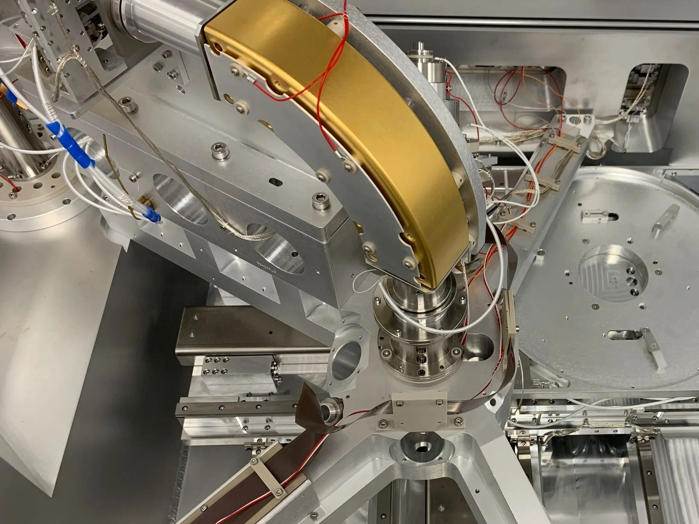 Close-up view of complex scientific machinery with metallic components, wires, and electronic parts.