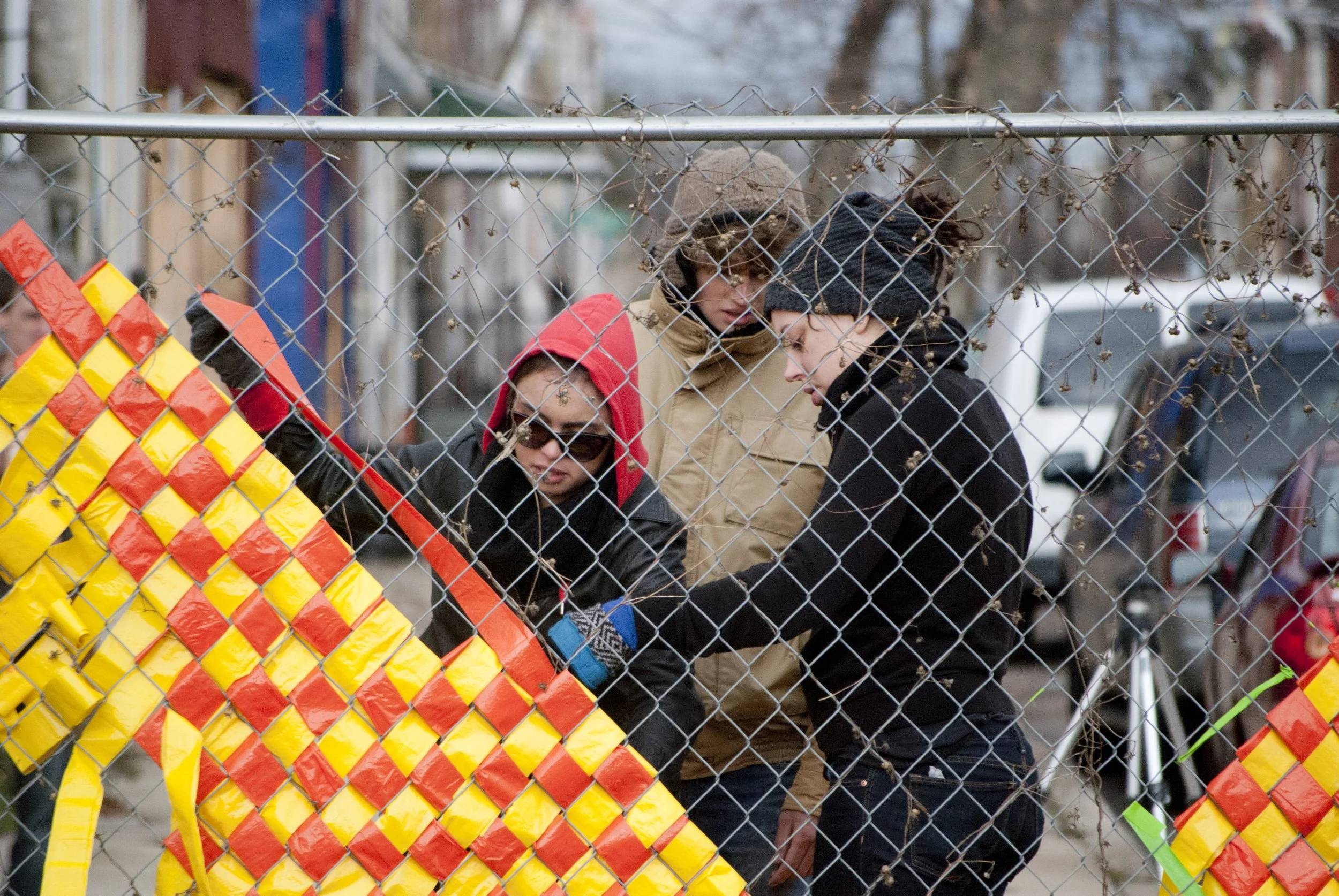 Volunteers working on weaving material into fence