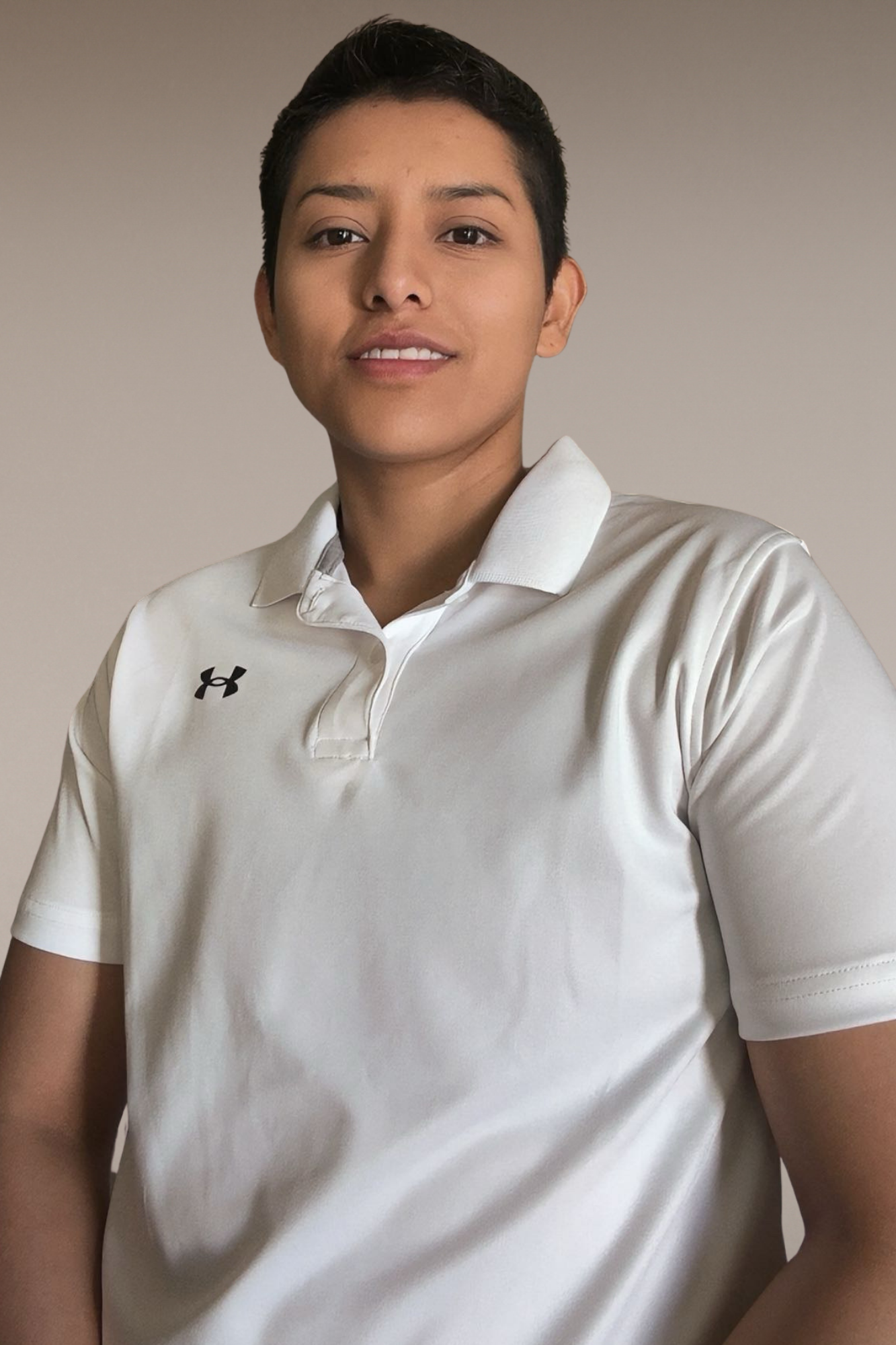 Portrait of Business Operator with short dark hair wearing a white Under Armour polo shirt, standing against a plain beige background.