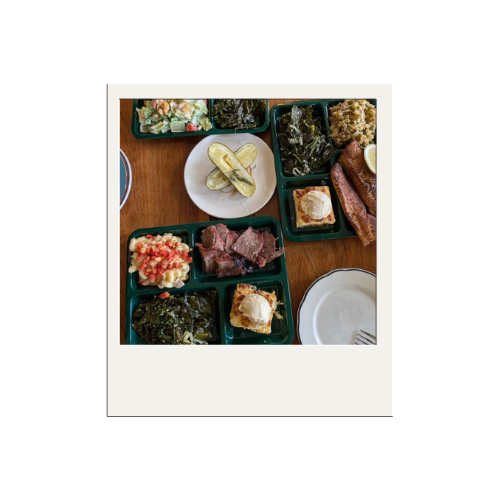 Assorted food items on a table, including small plates with appetizers, salad, bread rolls, and various cooked dishes.