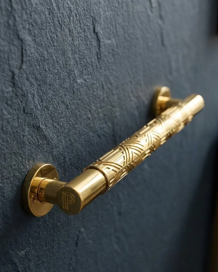 Close-up of a gold decorative door handle on a textured dark blue door.