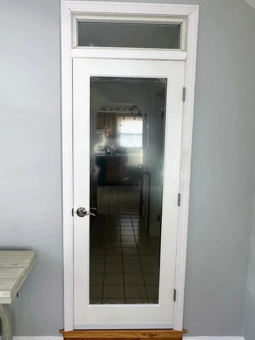 Interior door closing up the hallway to a four season room with a transom