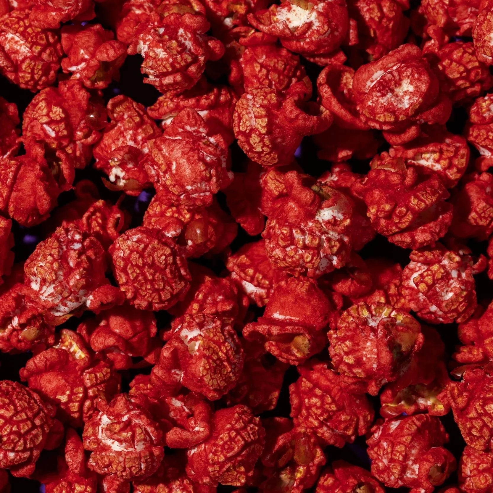 Close-up of red popcorn coated with a red-colored glaze or seasoning.