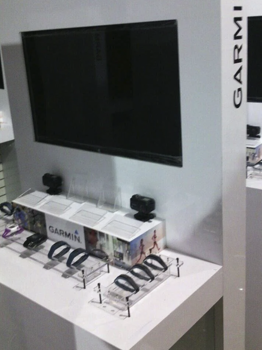 Pantalla grande y productos de Garmin en una exhibición en una tienda de electrónica.