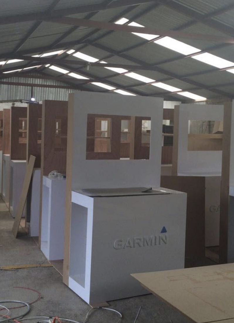 Interior de un almacén con estructuras de madera y un equipo Garmin en una mesa.