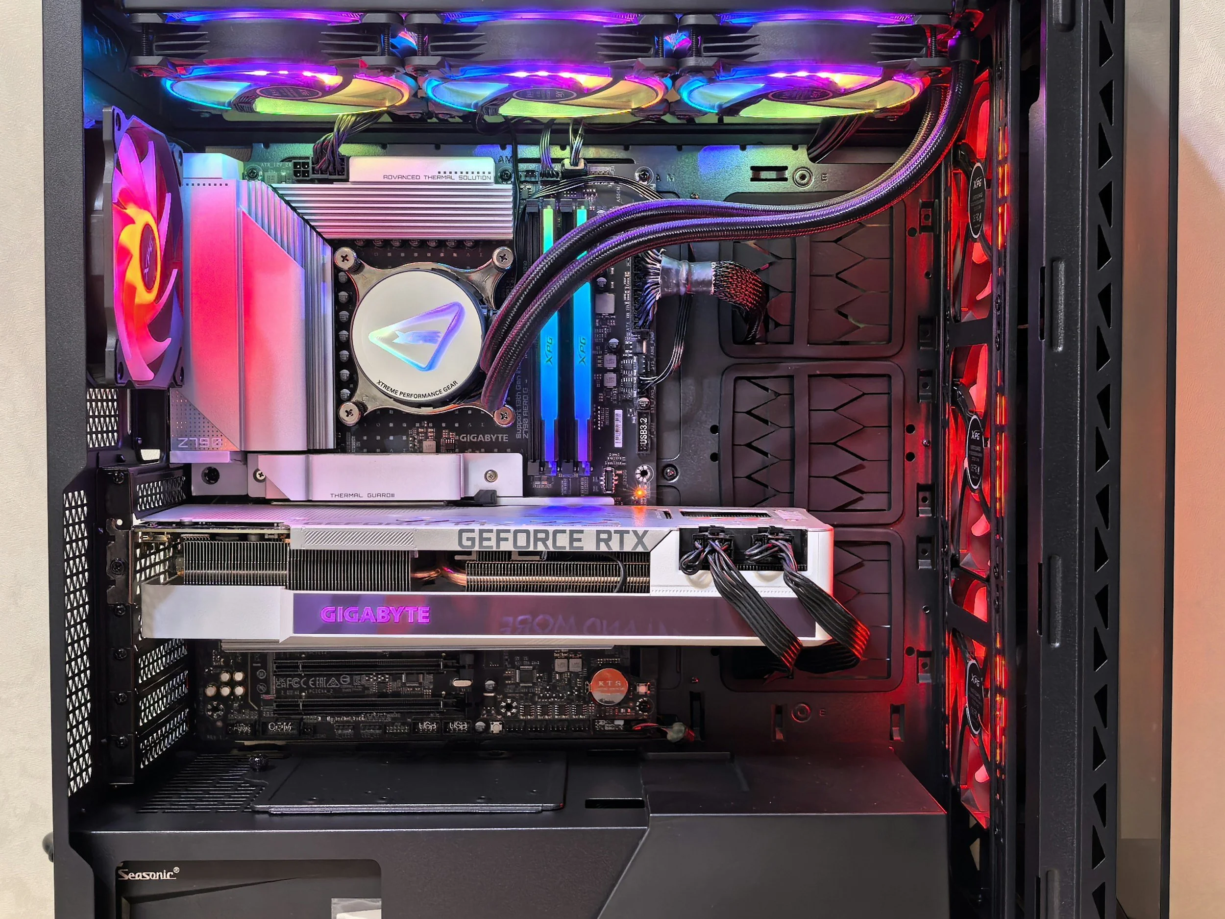 Inside a custom gaming computer with RGB lighting, showing a graphics card, cooling system, and multiple fans.