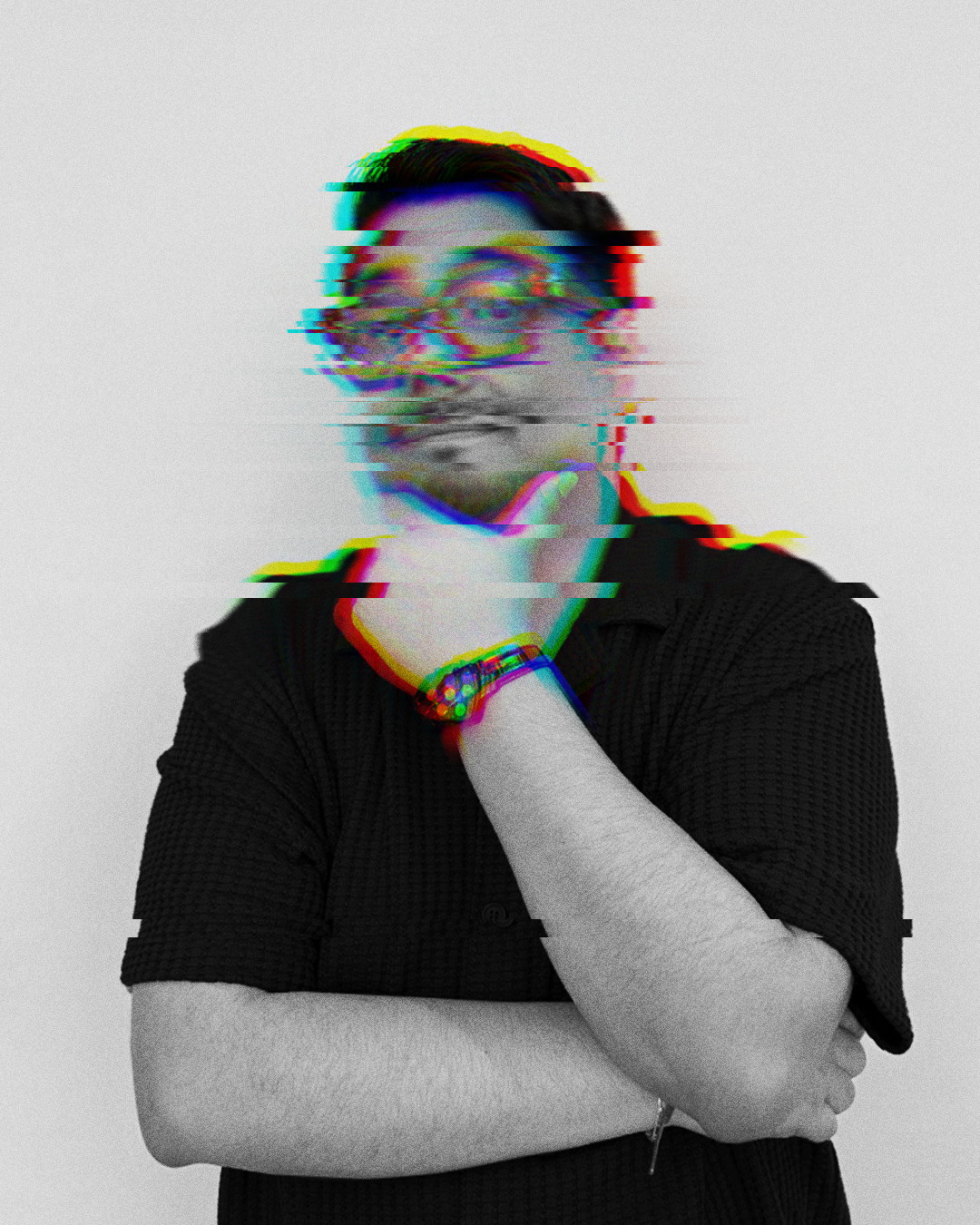 Persona con gafas, cabello oscuro y camisa negra, con efecto de distorsión digital en la cara, en fondo gris.