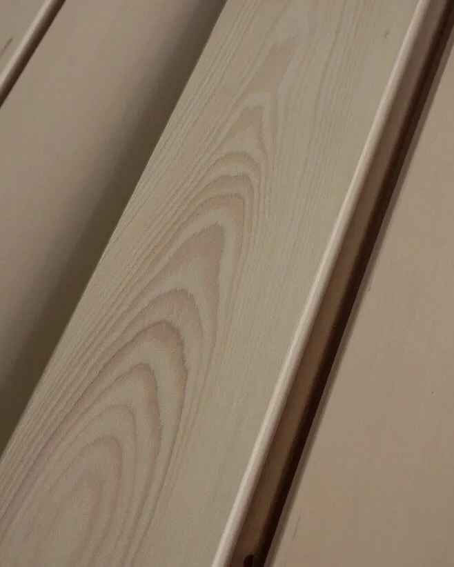 Close-up of a light-colored wooden plank with visible wood grain patterns