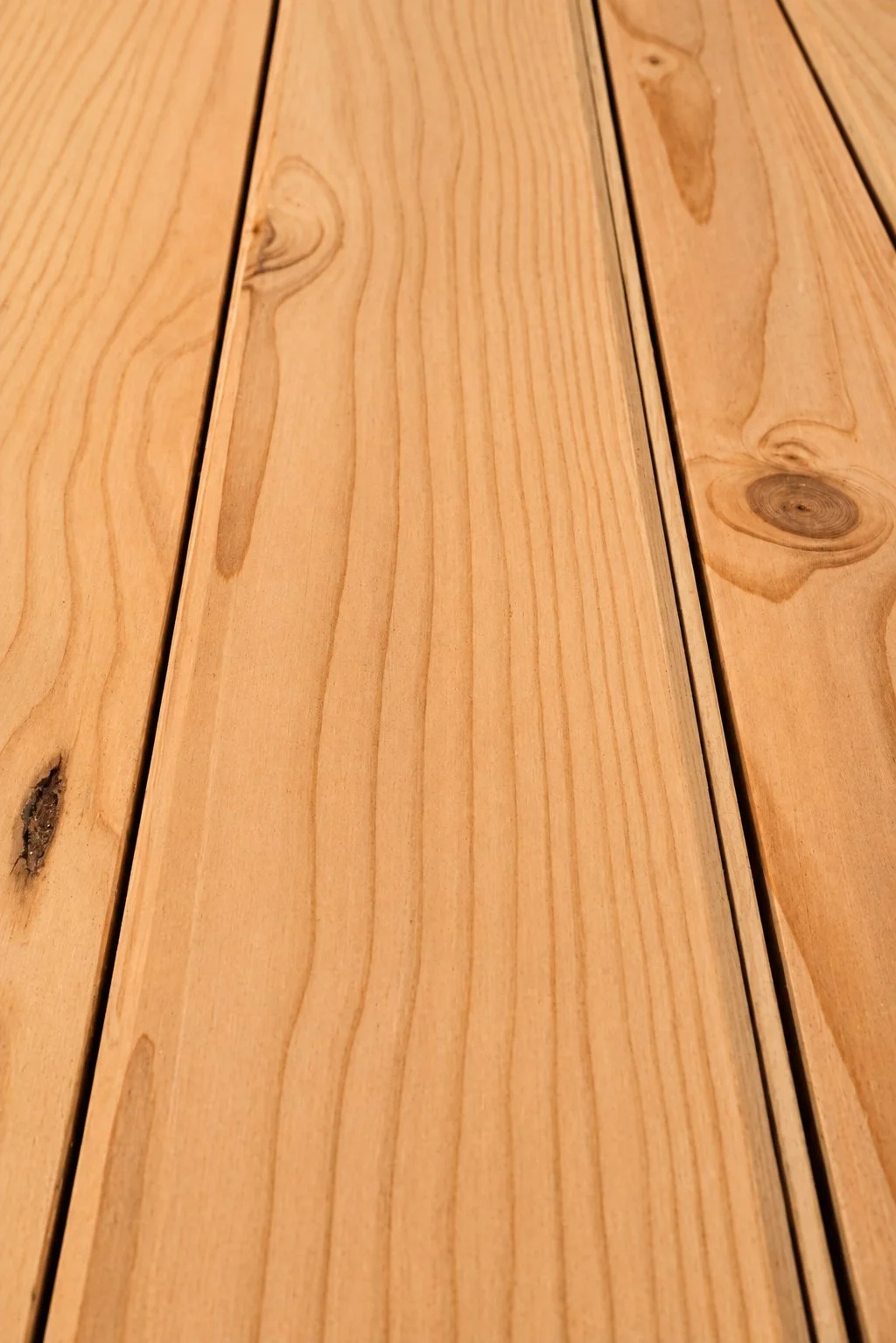 Close-up of a wooden tabletop with visible wood grain and knots.