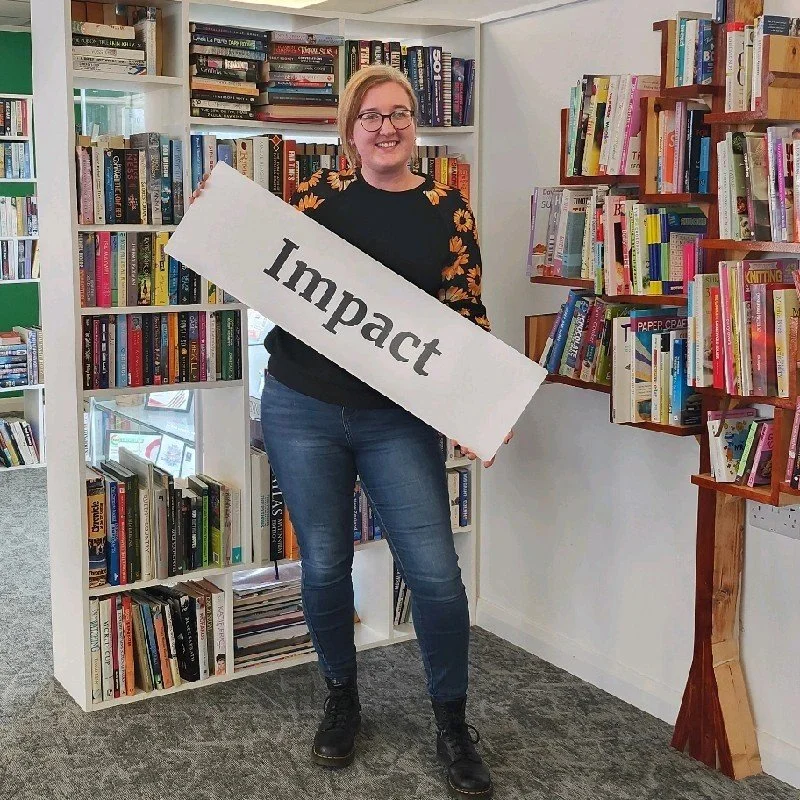 Hannah Clevett, image showing Hannah showing an sign saying 'impact'