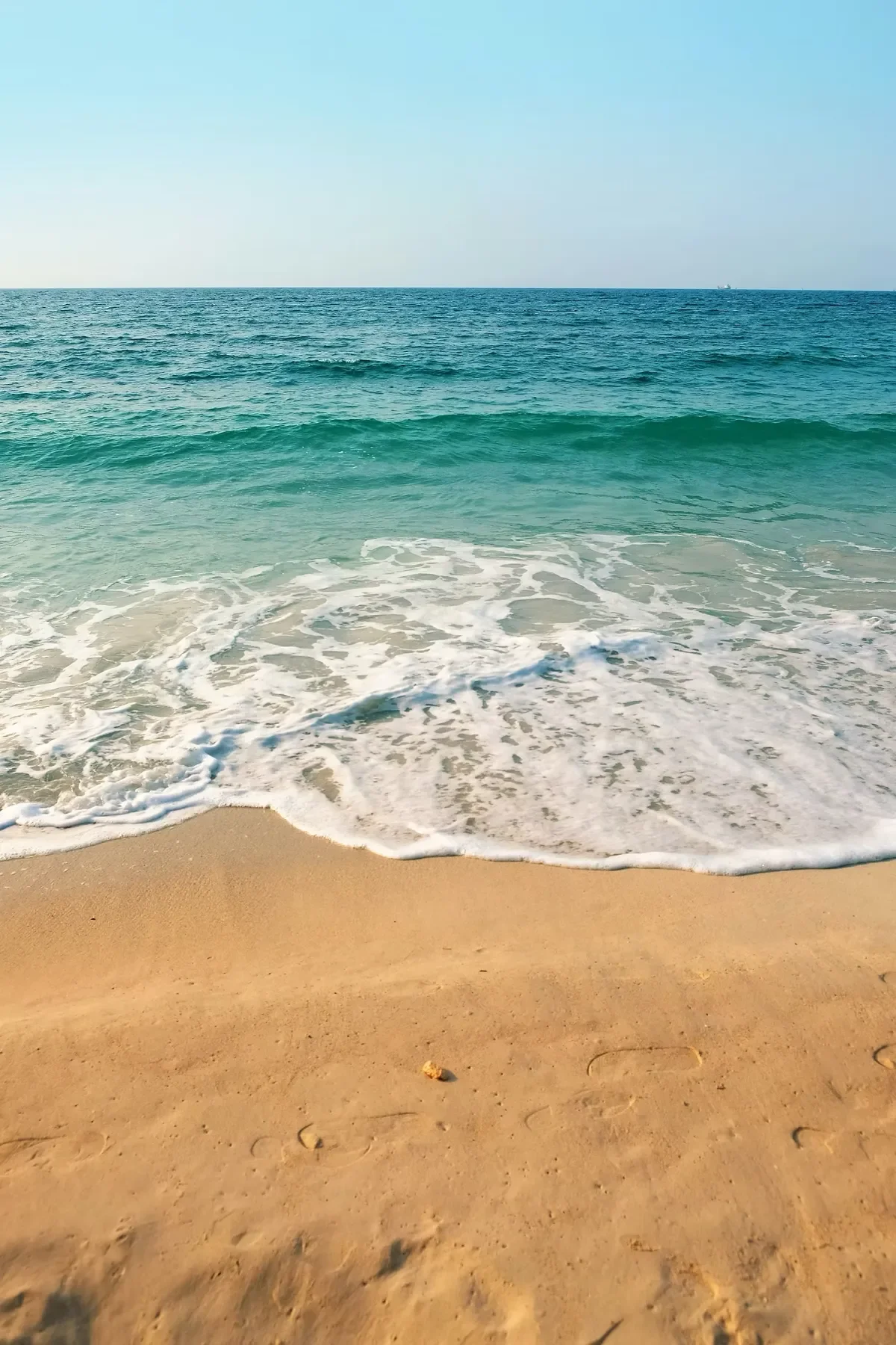 View of the tide rolling in on a sandy beach