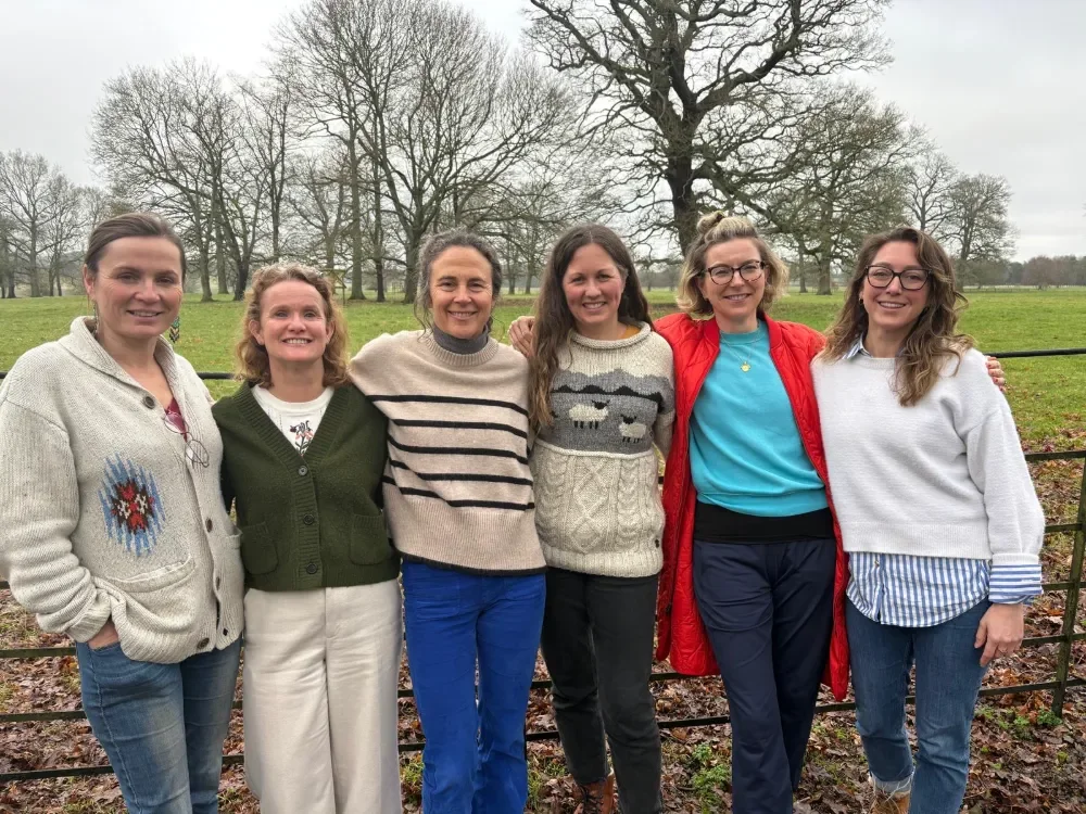The B Bolder Collective, group of B Corp consultants, standing together in a green field