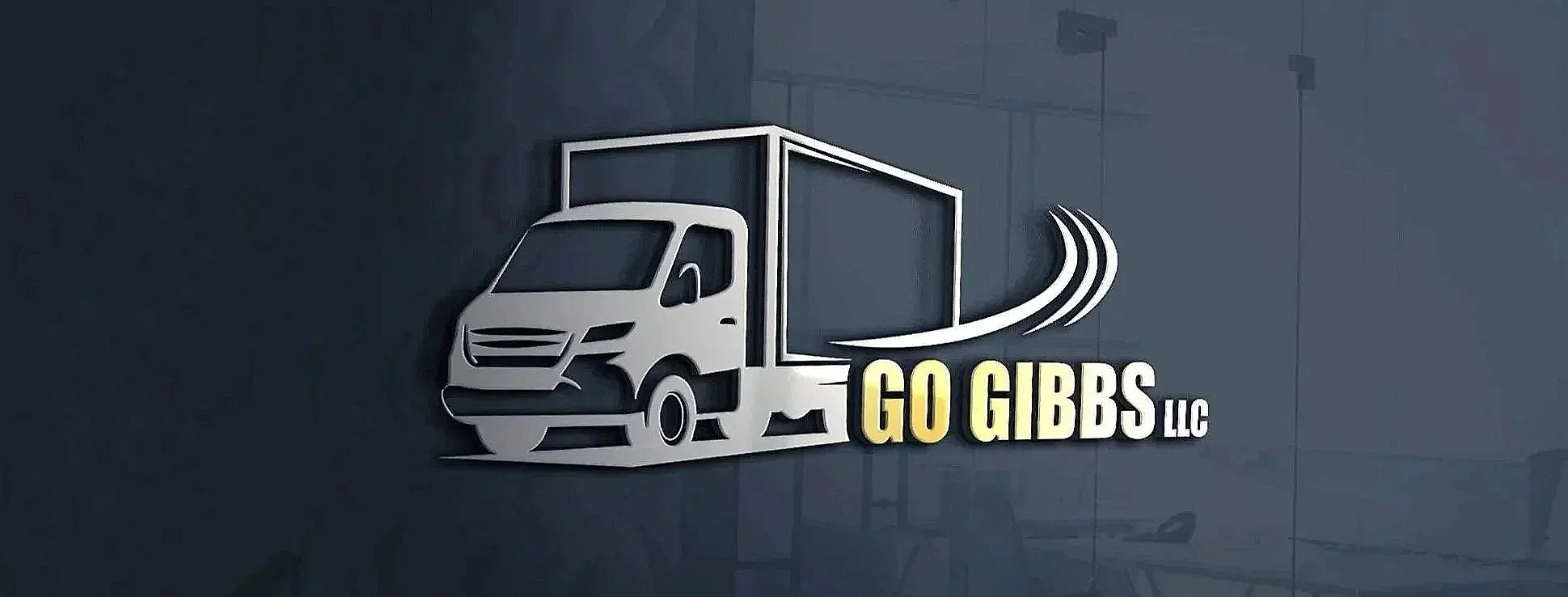 A 3D sign of a delivery truck logo with the text "GO GIBBS LLC" on a dark wall.