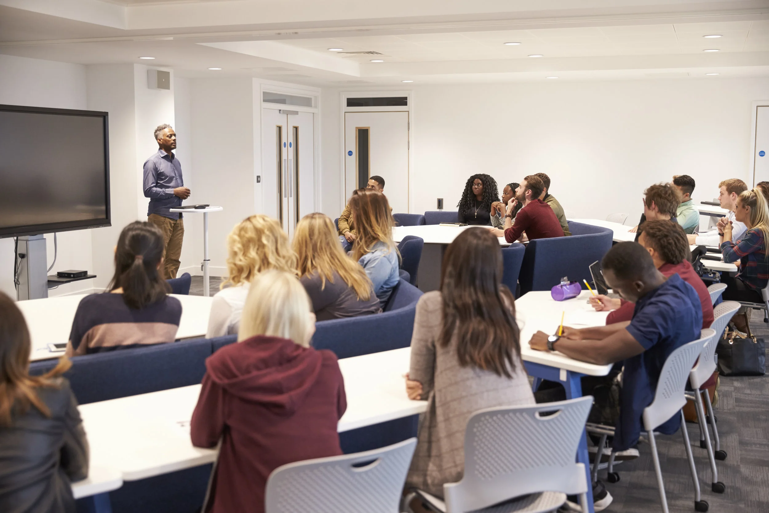 A presenter speaks to an audience in a seminar classroom
