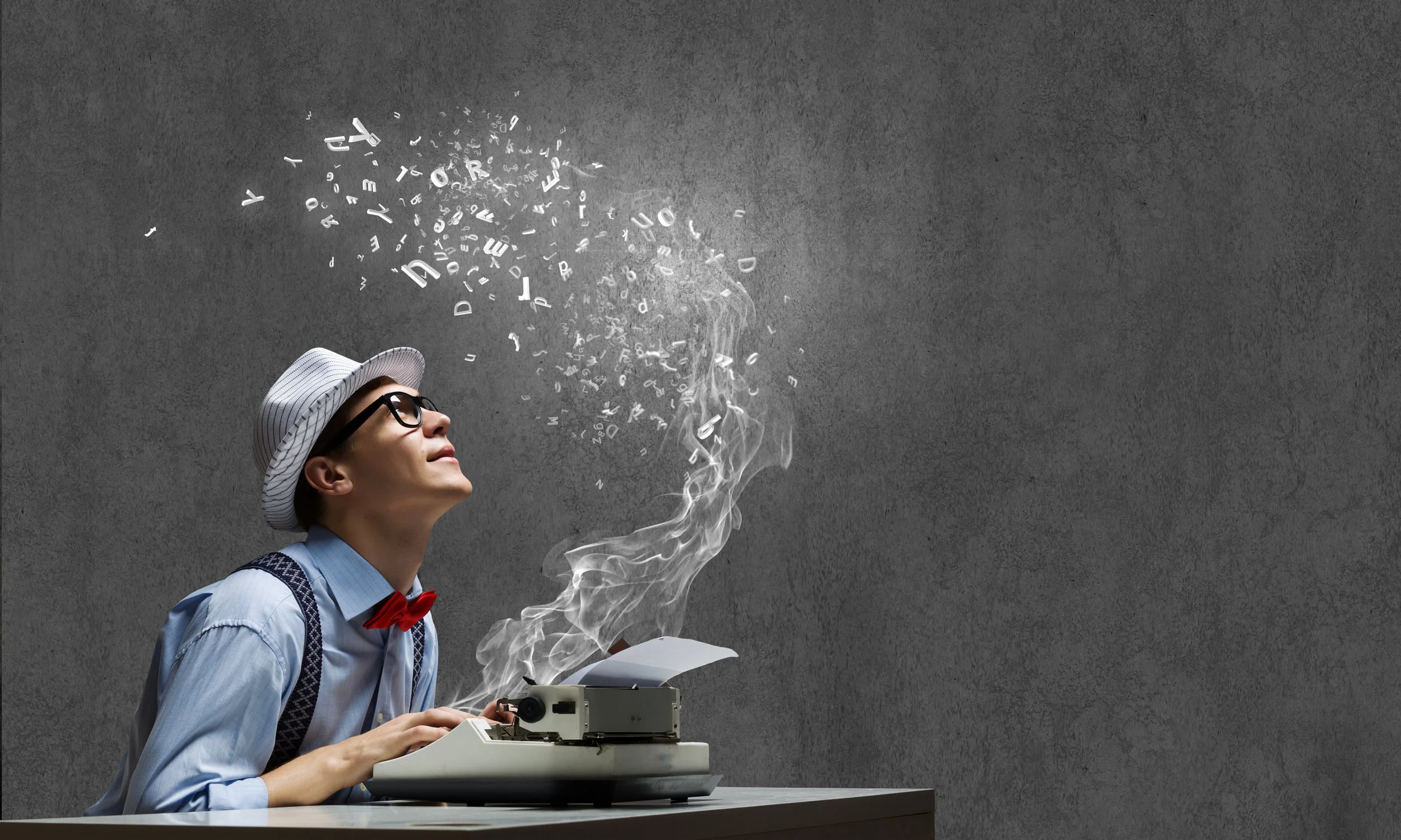 A man hovers over a typewriter, which emits letters into the air above him
