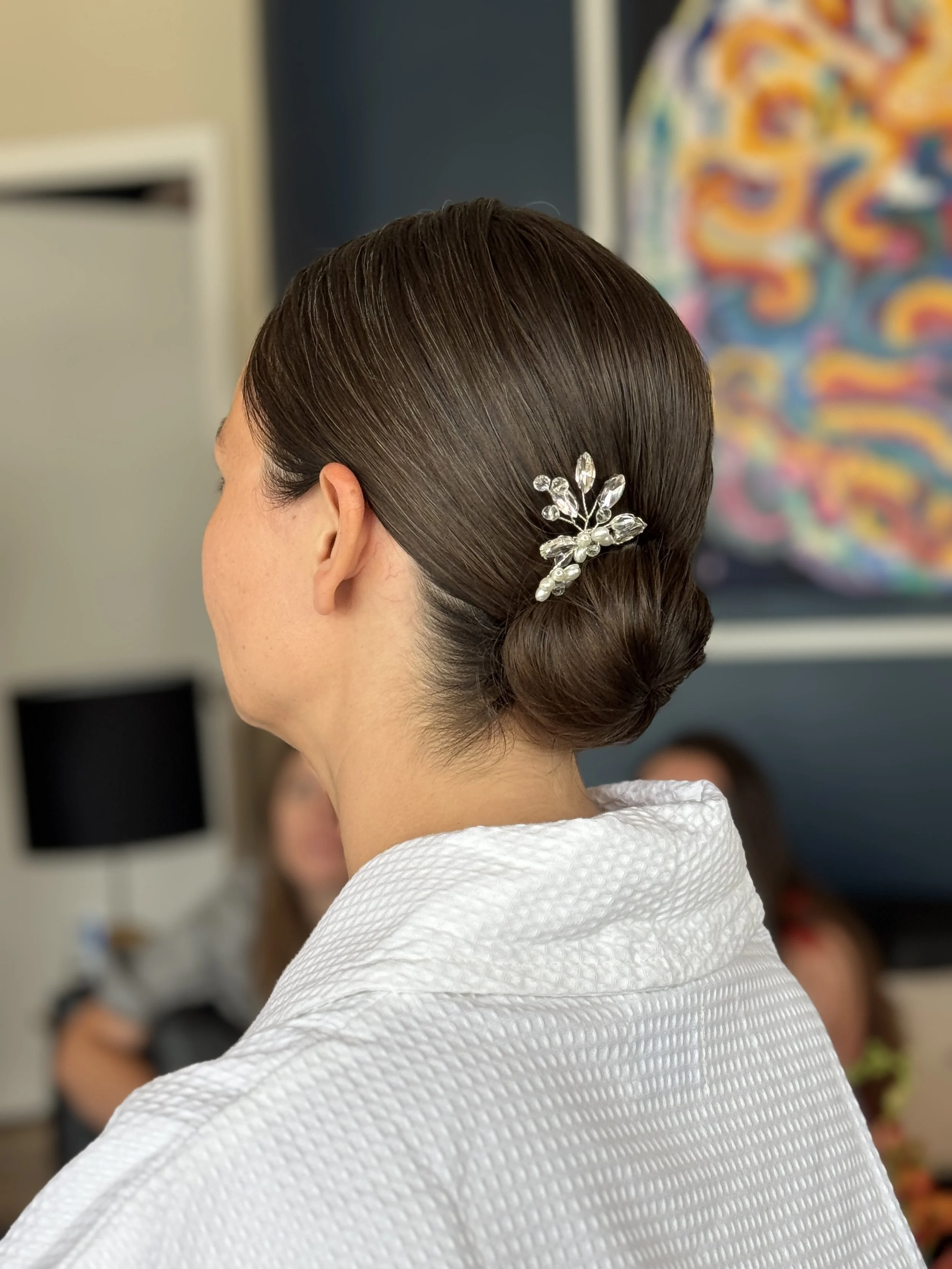 Elegant updo with a decretive hairpin for her wedding day.