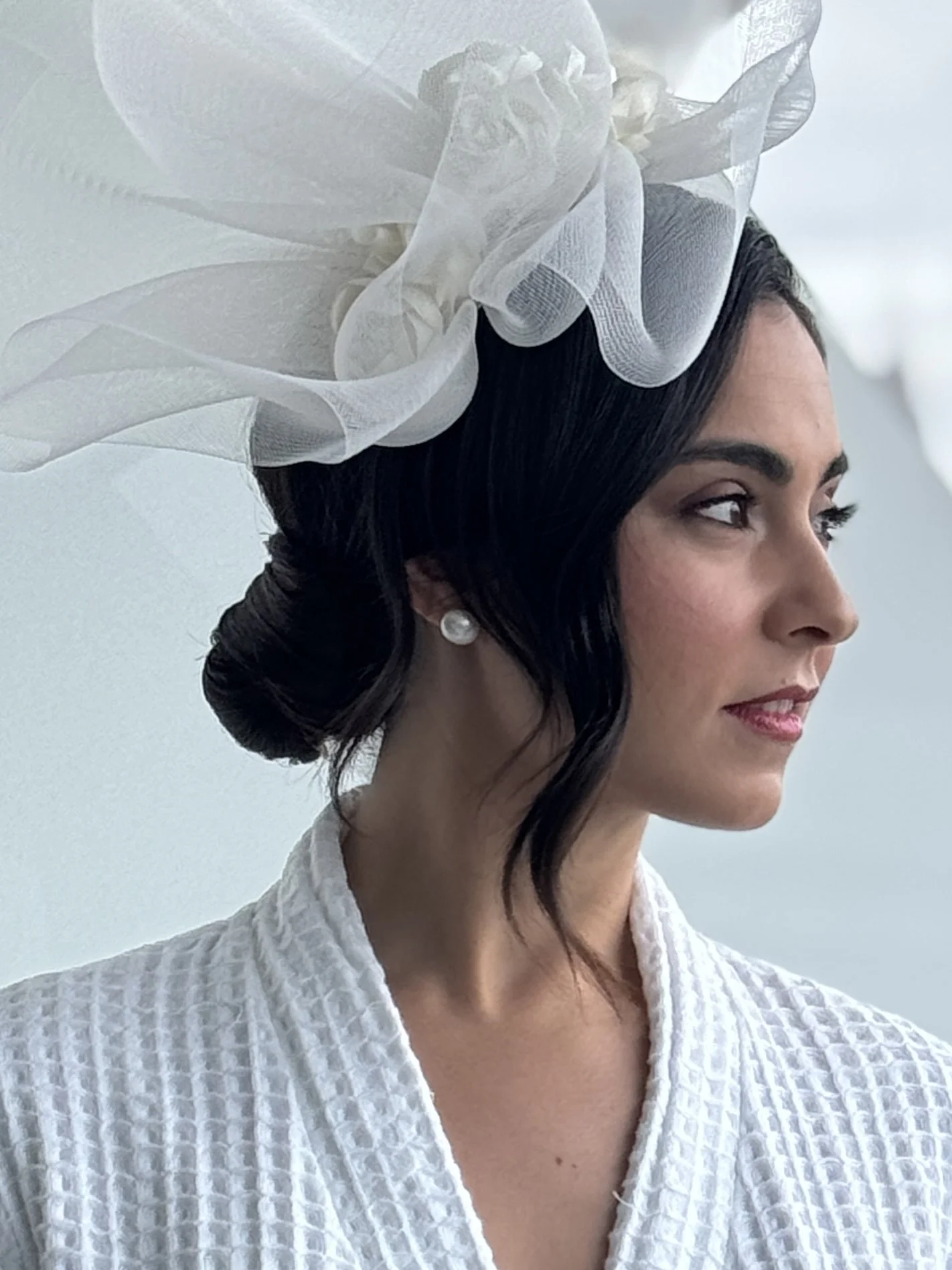 Elegant up-do with a side part and a head dress for a bride on her wedding day.