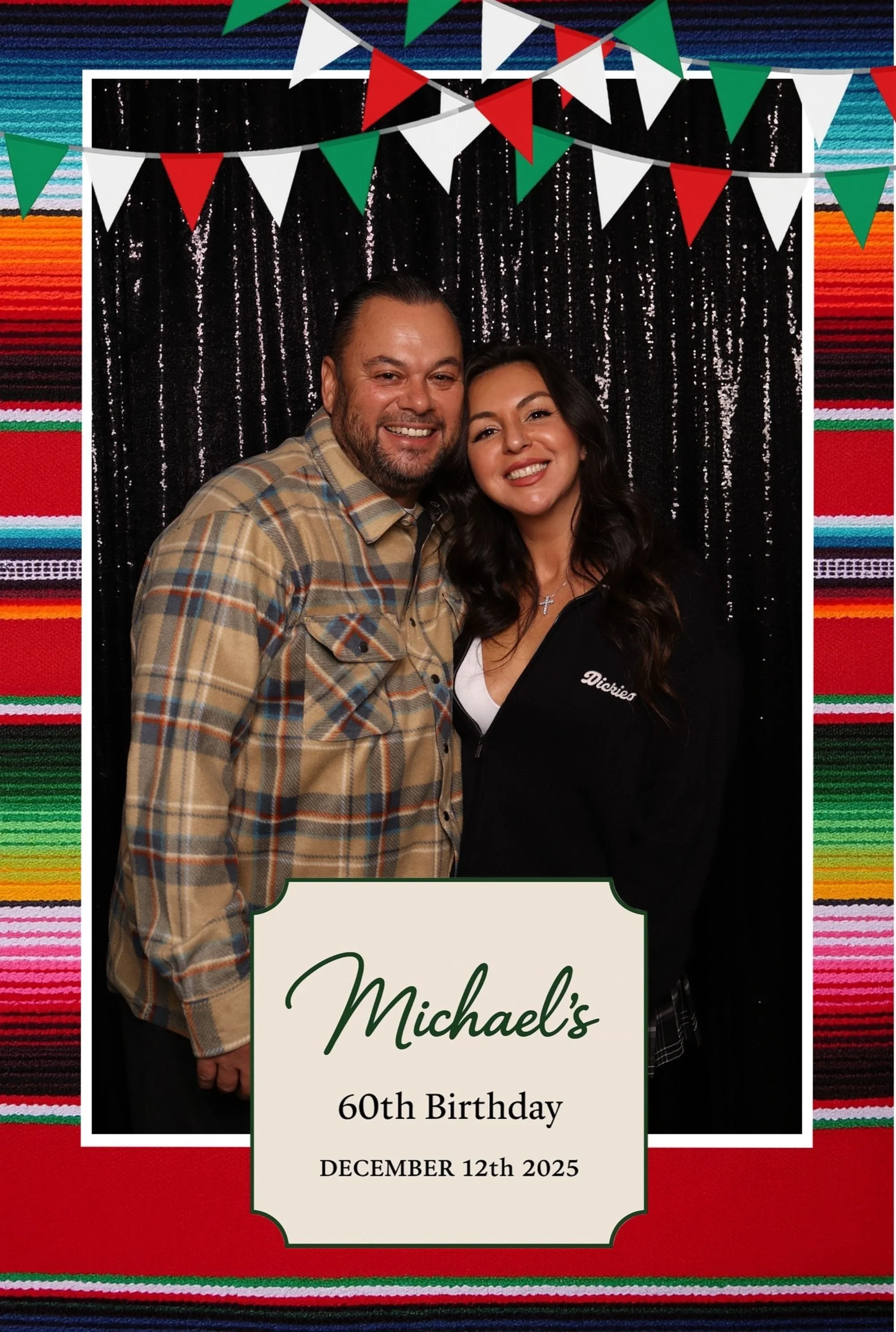Photo of a man and woman smiling in front of a decorative backdrop with Mexican-themed bunting and a sign reading 'Michael's 60th Birthday December 12th, 2025.'