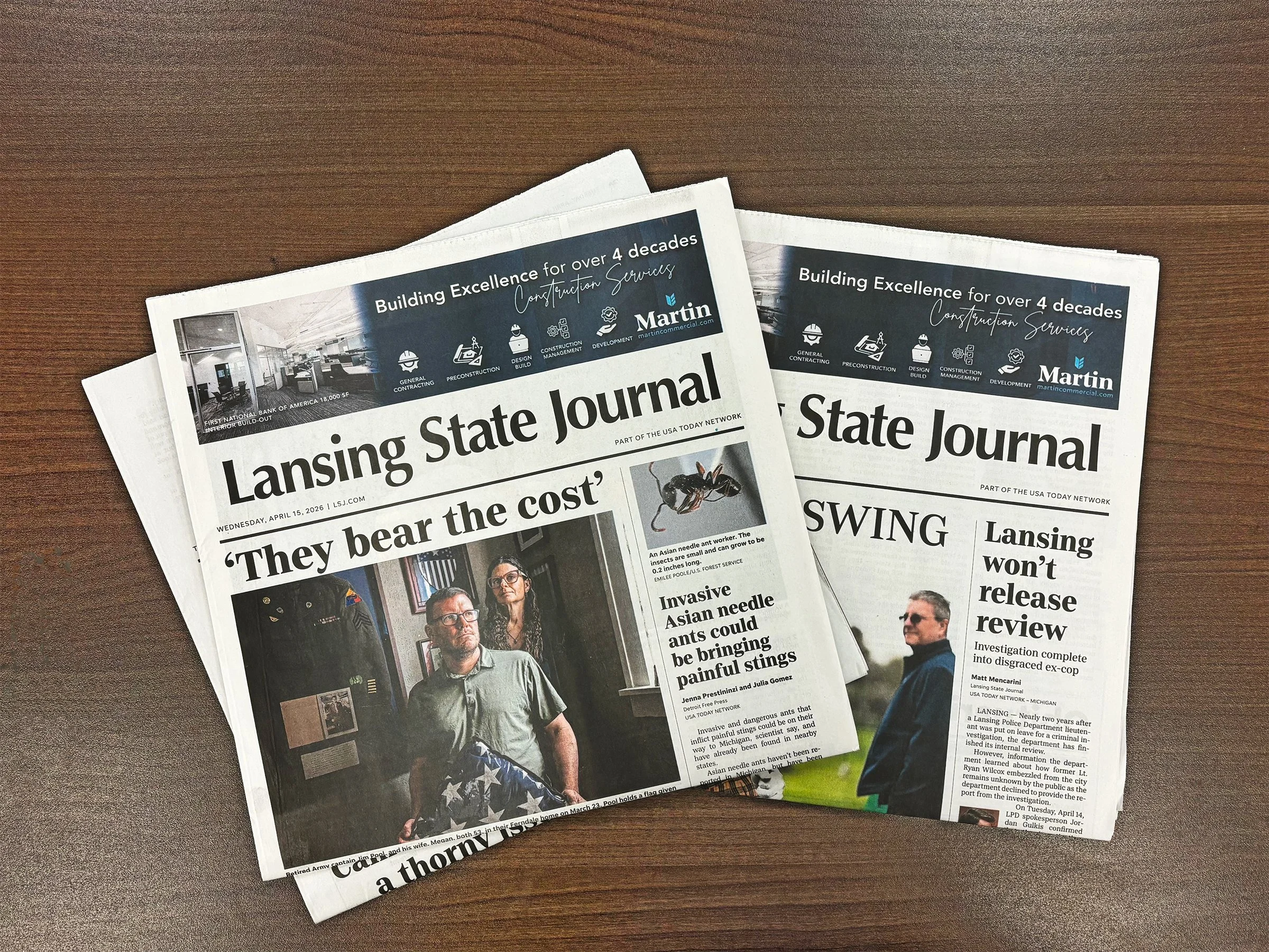 Two newspapers on a wooden surface, featuring advertising for Martin Commercial Properties.