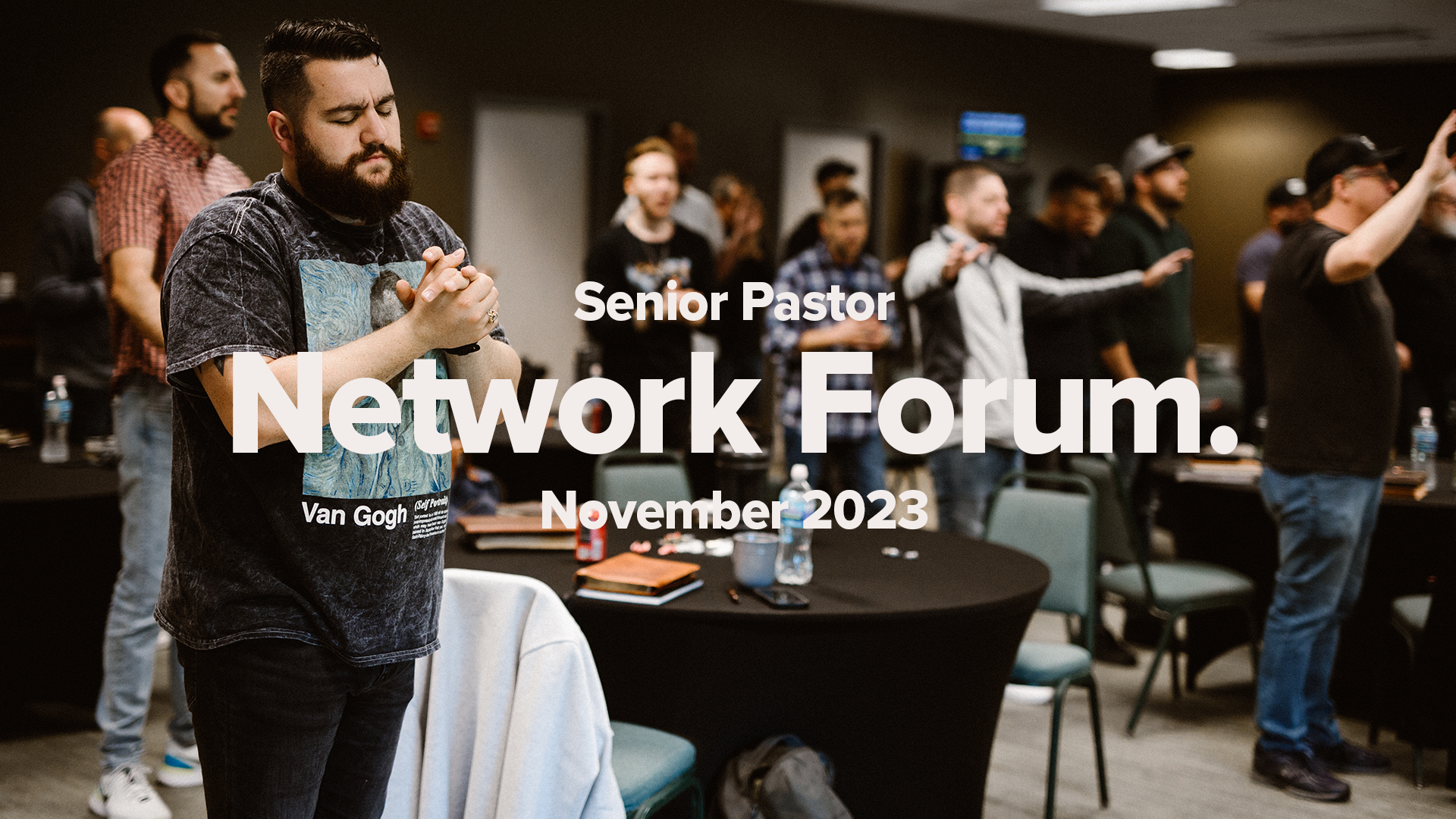 Pastors gather in a room, worshiping around round tables. Seior Pastor Network Forum November 2023 Promotion