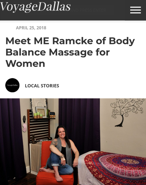 Woman sitting on an orange chair in a massage therapy room with purple curtains, a bookshelf, and a decorative wall tree with swirls.