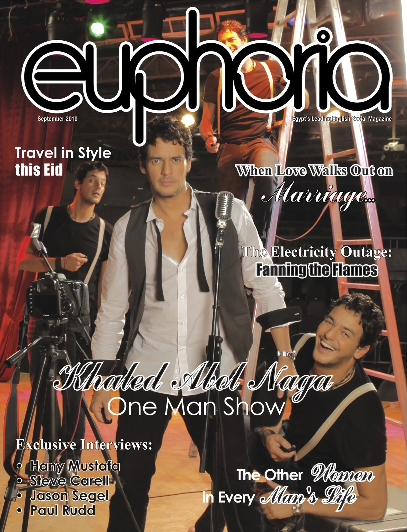The cover of a magazine titled 'Euphoric' features four men in a studio setting with equipment and a ladder. The main man in front wears a white shirt and a black vest, standing near a camera. The others are positioned behind him, smiling or looking 