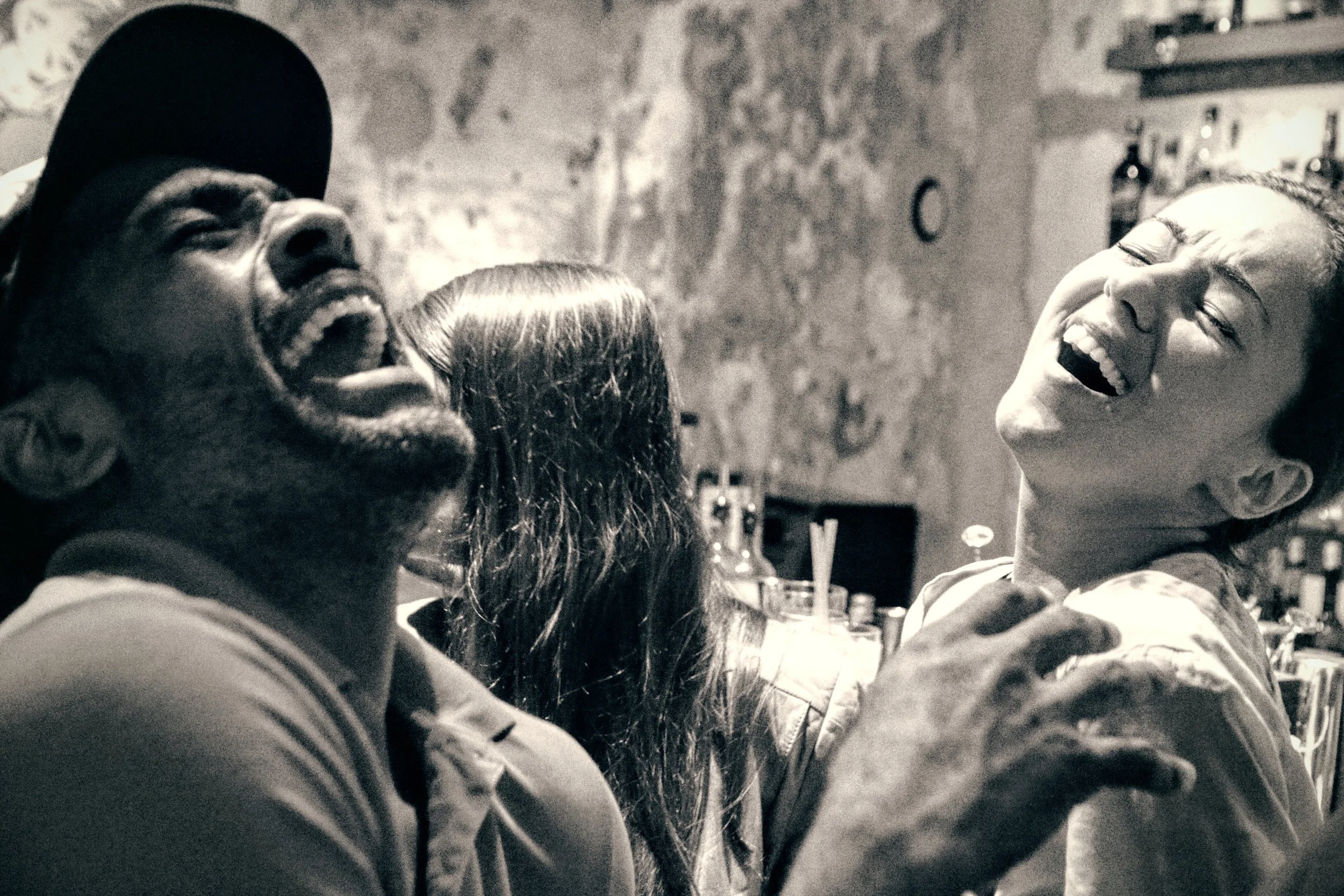 Four friends sharing a joyful moment and laughing together in a cozy indoor setting.