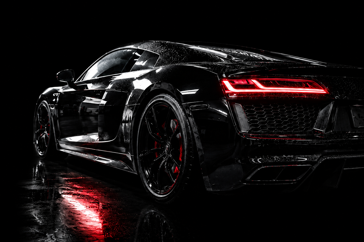 Voiture de sport noire avec feux arrière rouges, images en basse lumière avec reflets au sol humide.
