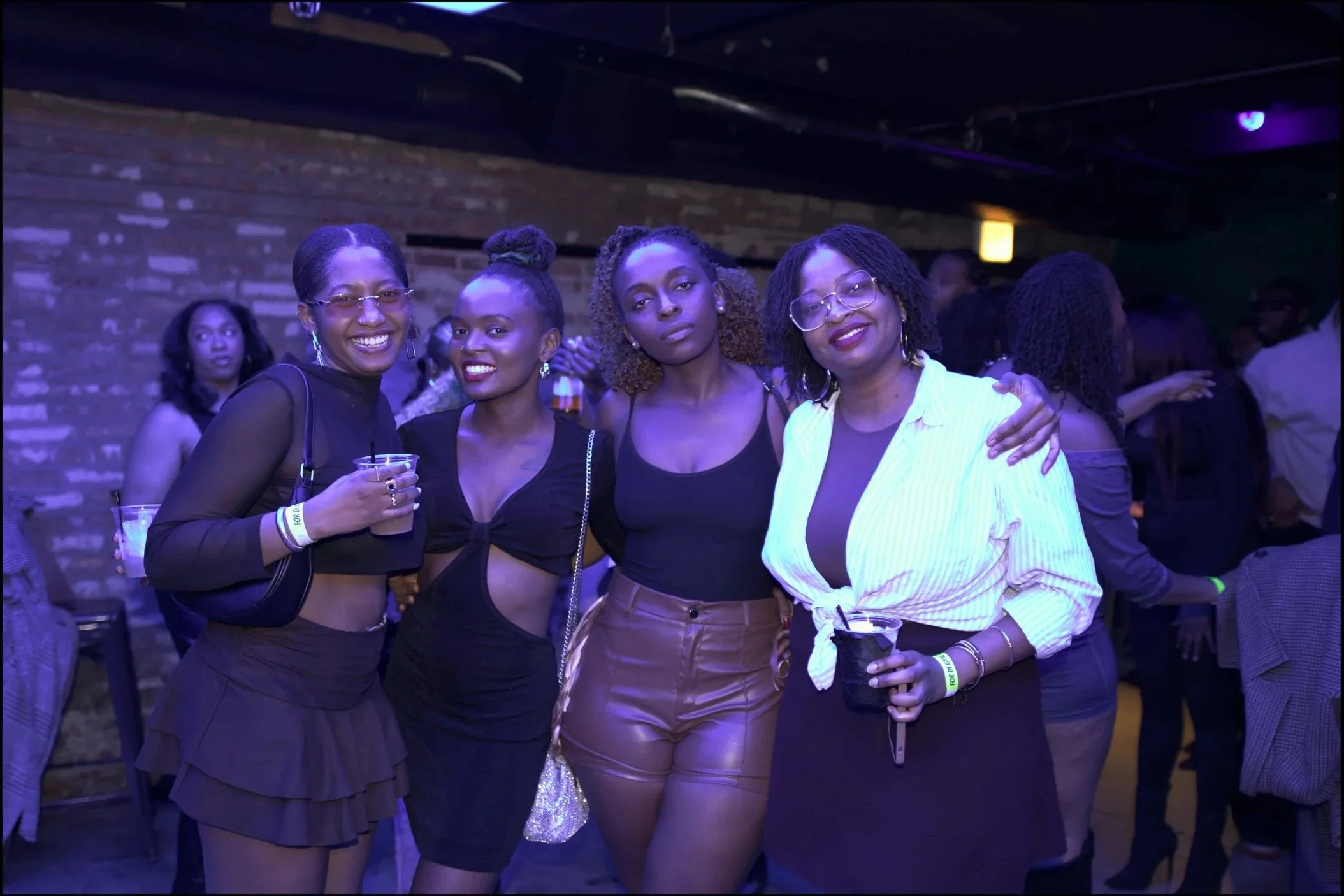 Four women on the dance floor taing a picture.