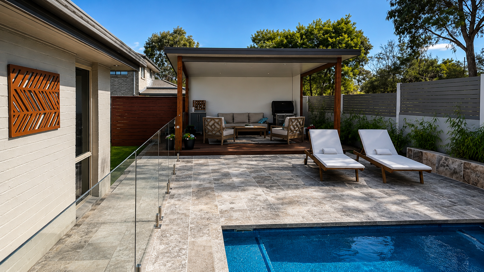 Backyard patio with a swimming pool, two white lounge chairs, and a covered seating area with sofa, chairs, and barbecue grill.
