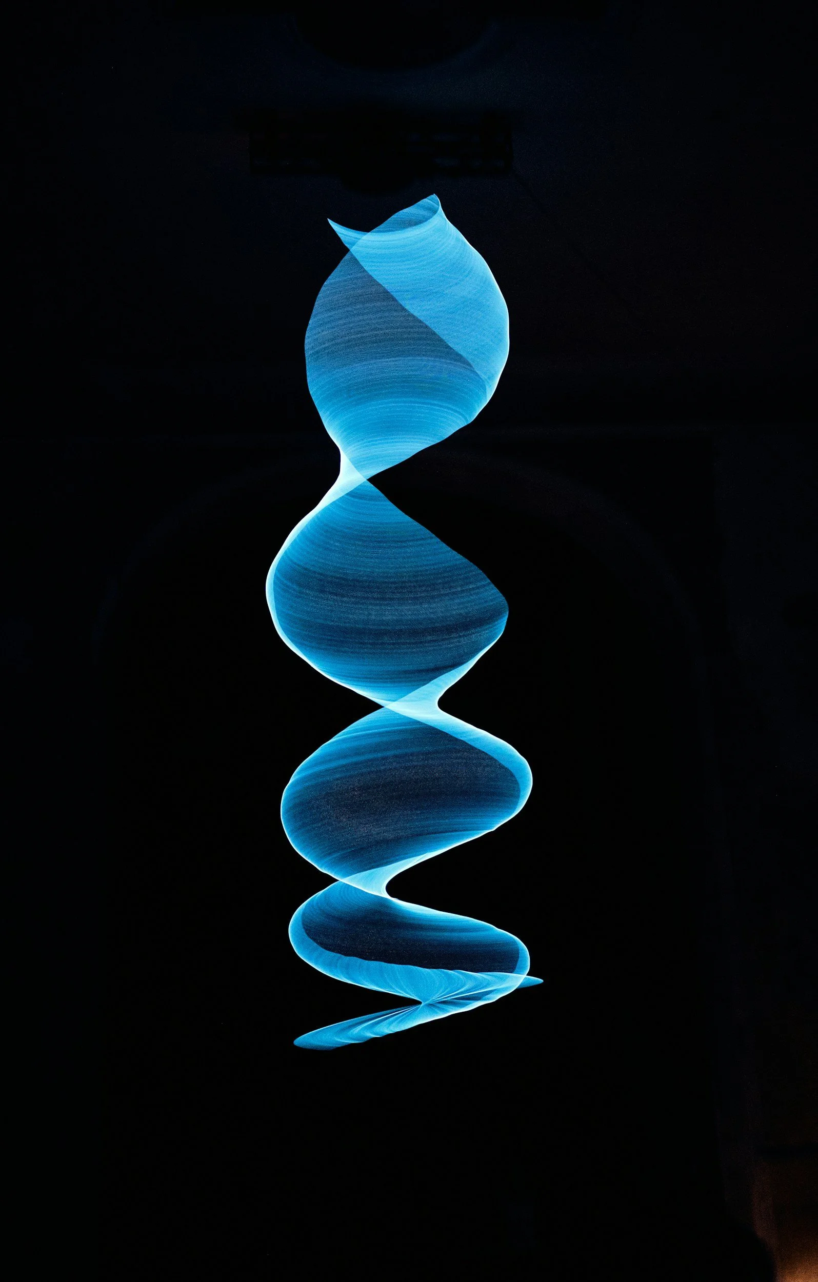 Blue spiral-shaped light trail against a dark background.