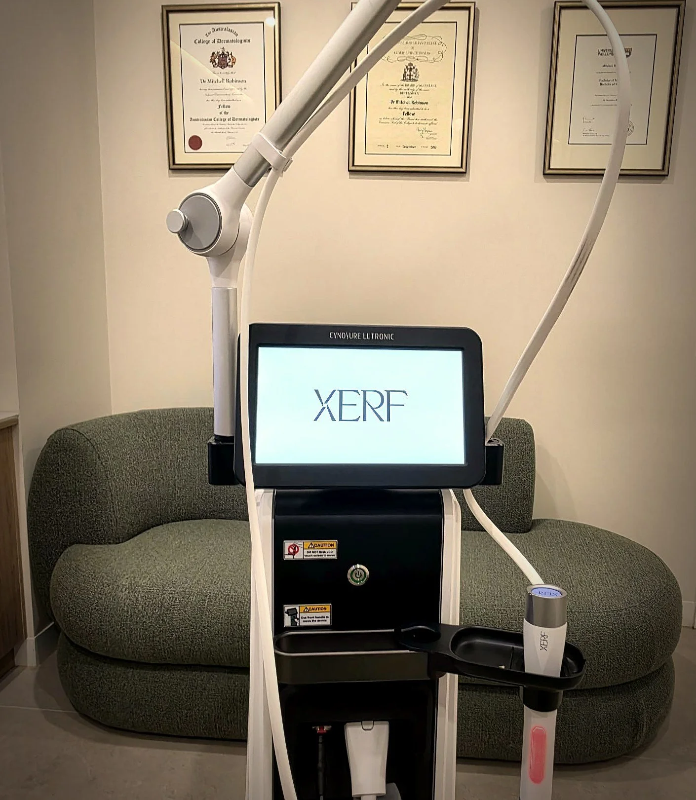 The XERF skin tightening device at DERM Skin Specialists, Mount Gravatt, in front of Dr Mitch Robinson's dermatology and general practice fellowship certificates