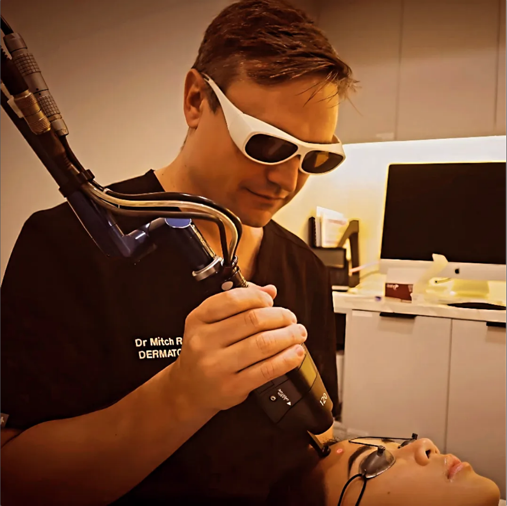 Dr Mitchell Robinson, specialist dermatologist, performing a laser treatment in Brisbane