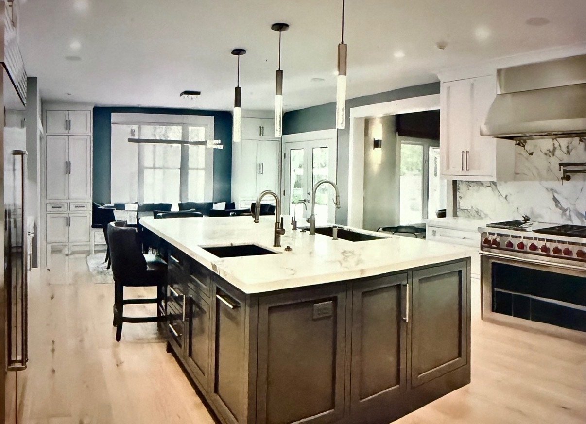 Modern kitchen with a large island, marble countertops, pendant lighting, and a stovetop with a vent hood.