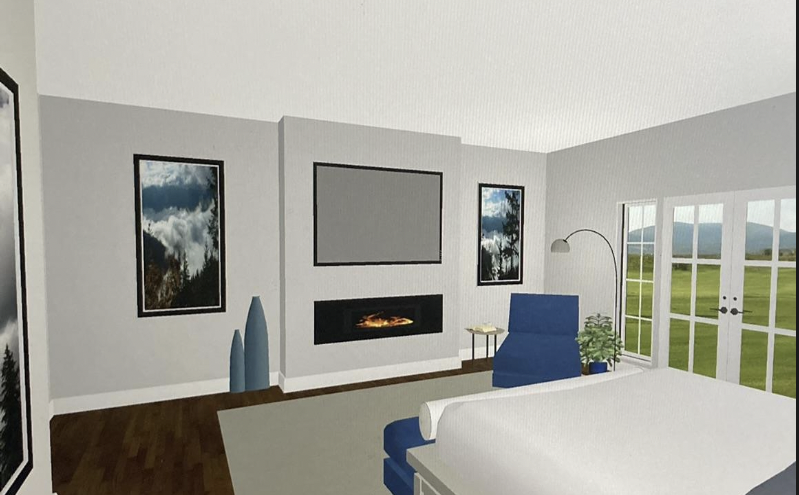 Living room with white walls, a gray fireplace, a mounted TV, framed mountain landscape pictures, a blue armchair, a floor lamp, large windows showing a green field and mountains, and a bed with white bedding.