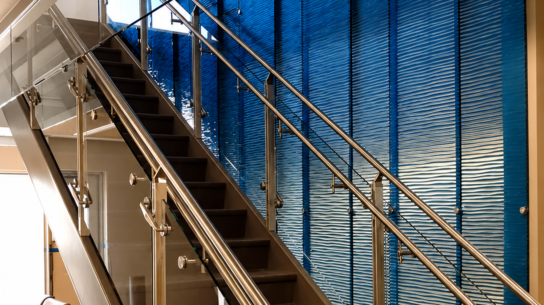 Interior of a modern building with a staircase and blue textured wall panels.